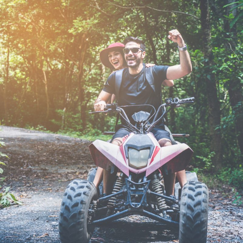 couple driving off road adventure with ATV,UTV bike quad bike on the mountain, A man show hand up.