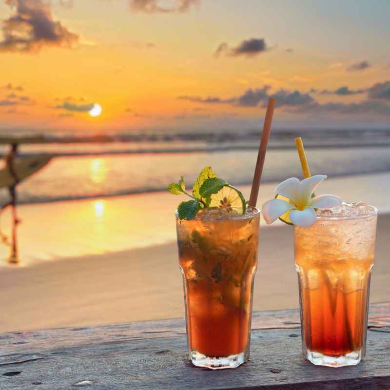 drinks with blur tropical beach and sunset in background