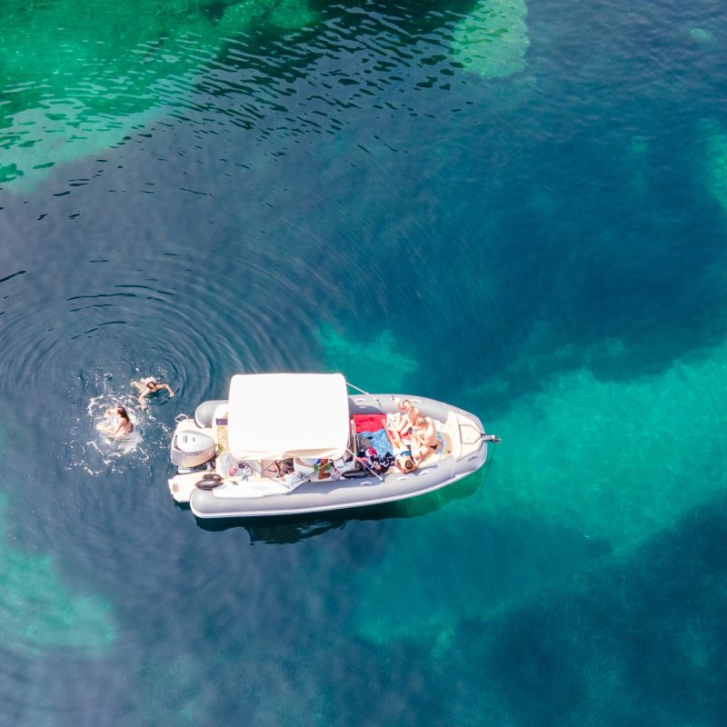 View of a private recreational boat with people swimming
